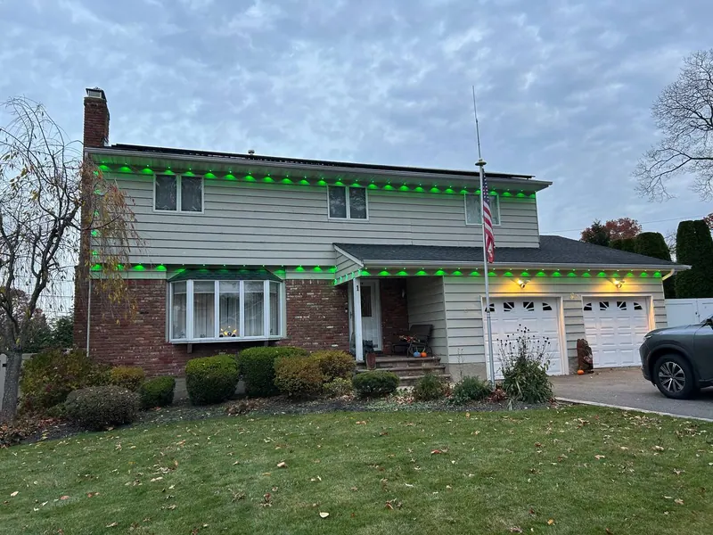 Green LED roofline lighting on a Long Island split level